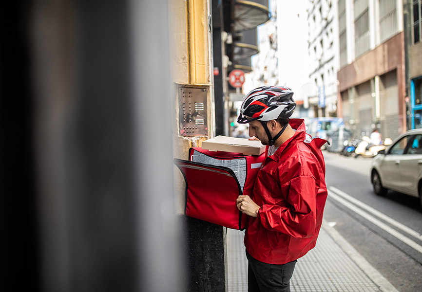 Man delivering pizza to building